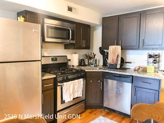 a kitchen with dark cabinets and stainless steel appliances